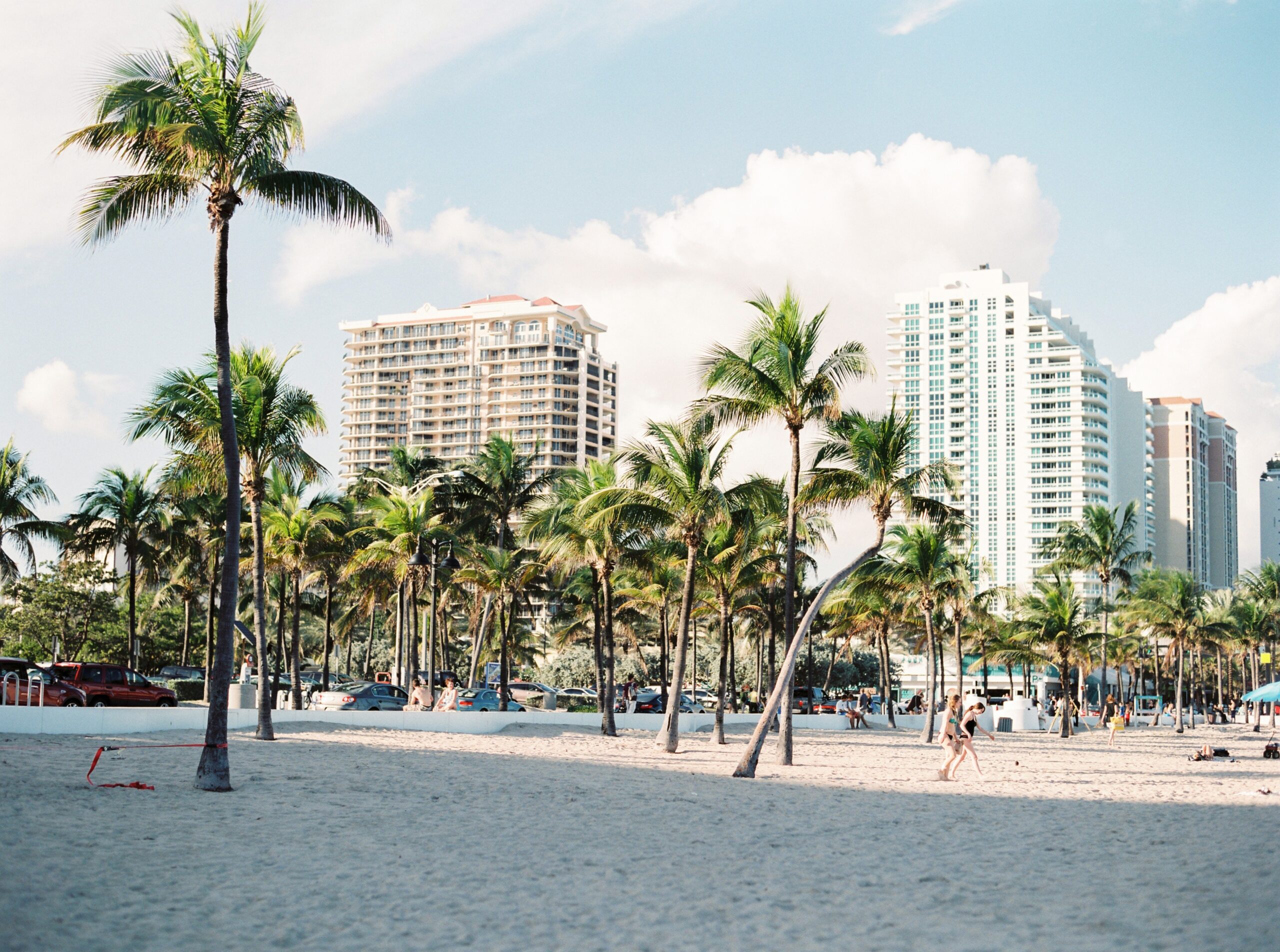 Beachside Miami featuring palm trees near buildings and children playing in the background