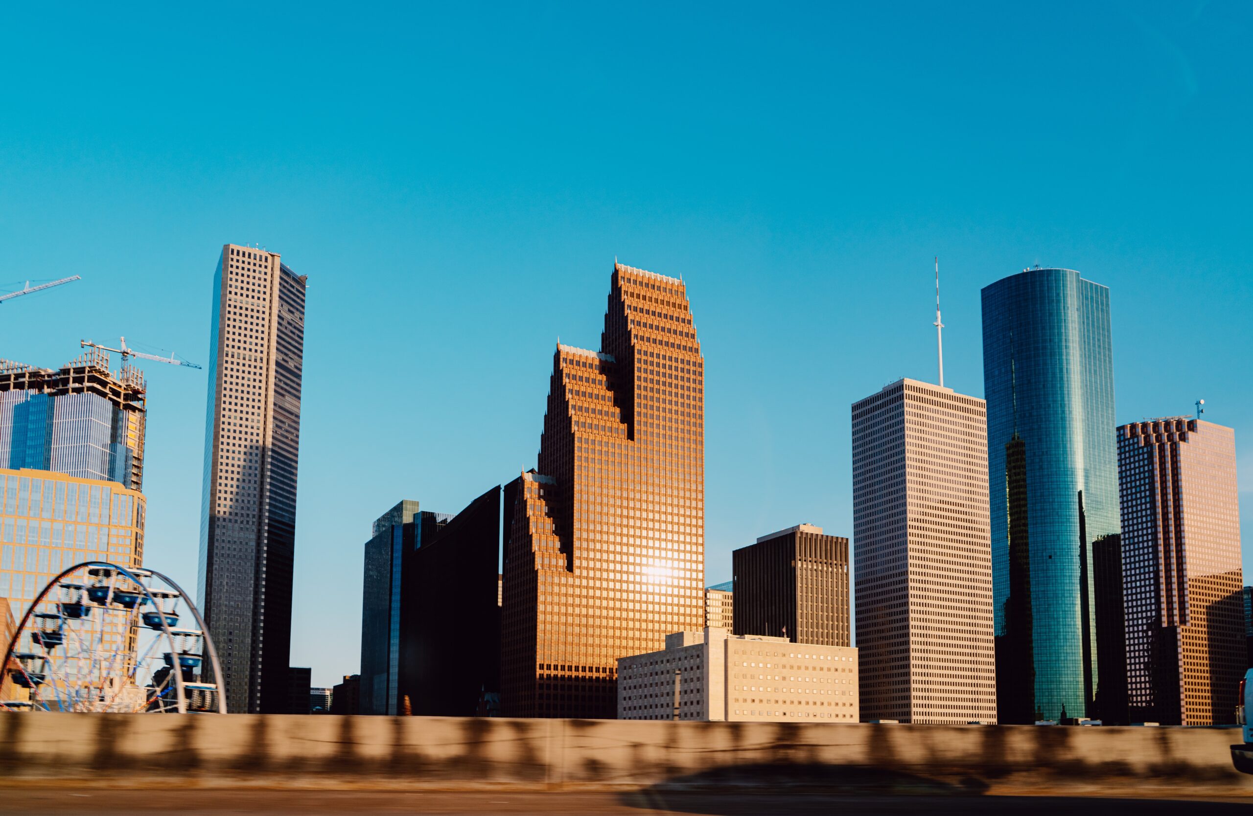 Sun reflected as it hits the large windows of a tall commercial building in Houston