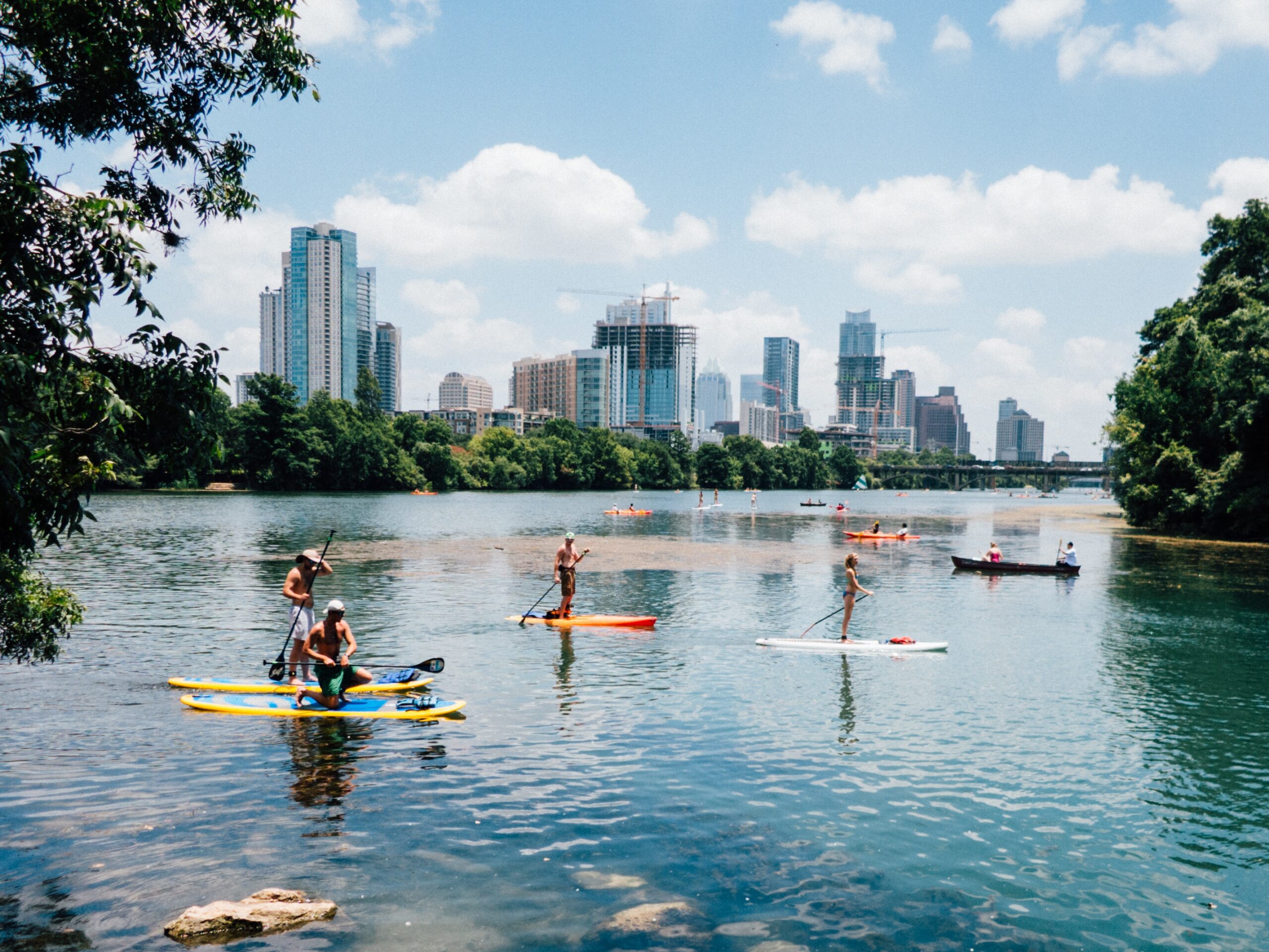 Young adults in their 20s and 30s paddleboarding in Austin during the summer