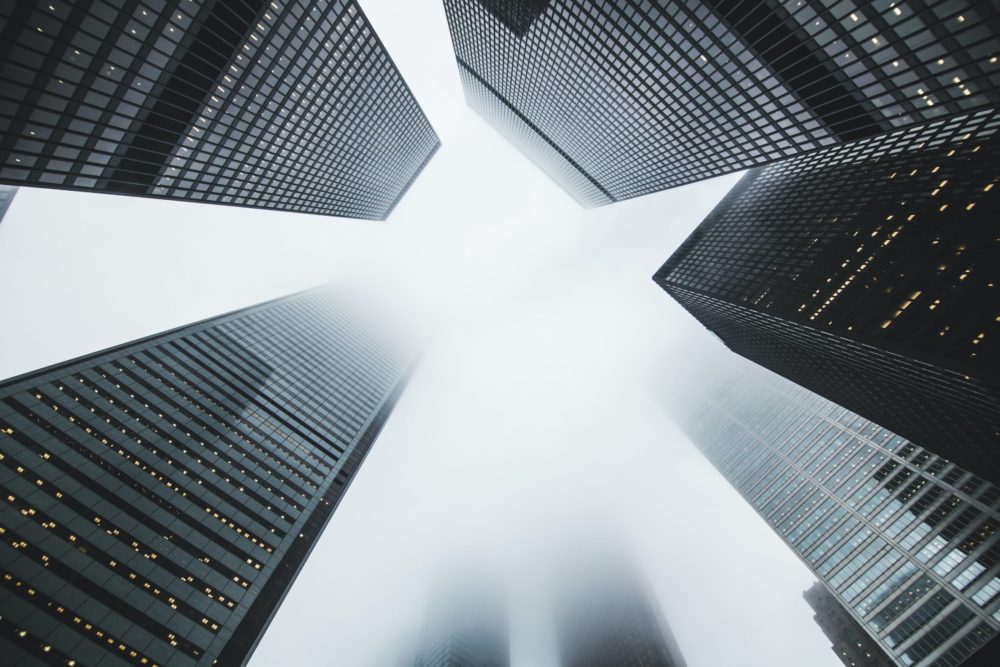 Black and white view of tall skyscrappers from below