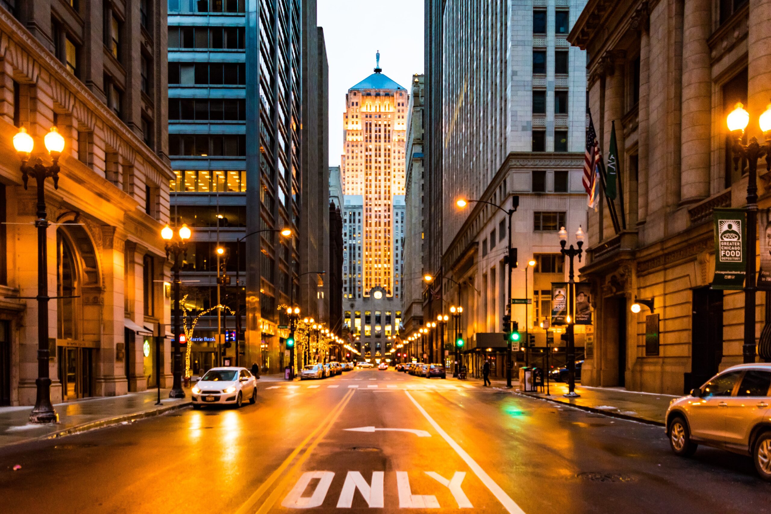 Large street in Chicago at nighttime illuminated with street lamps