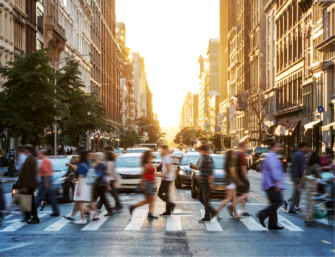 A crowd crossing the streets within a city to represent demographics data